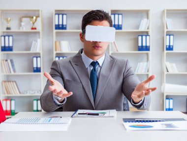 Ofiste sanal gerçeklik gözlüklü bir iş adamı var.