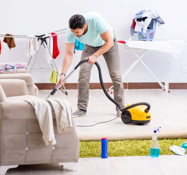 Mladý muž manžel dělá vysávání doma — Stock fotografie