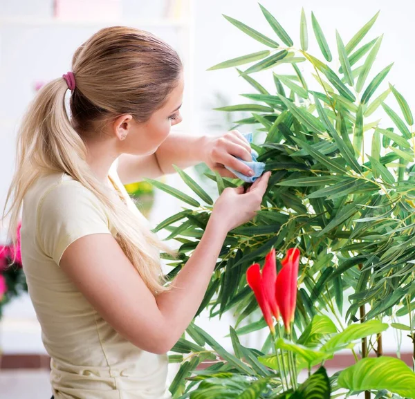 Молодая женщина поливает растения в своем саду — стоковое фото