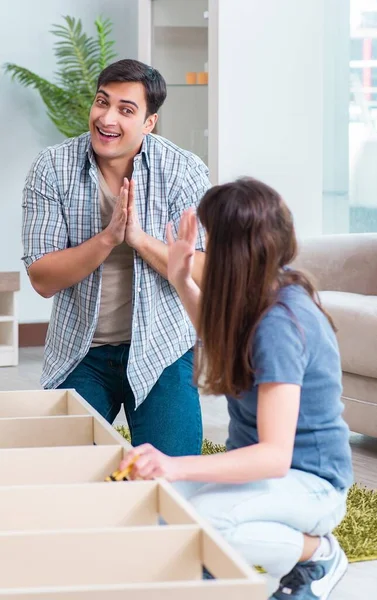 Joven familia ensamblando muebles en casa nueva —  Fotos de Stock