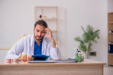 Klinikte çalışan genç bir erkek odontolog.