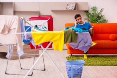 Genç adam evde ütü yapıyor.