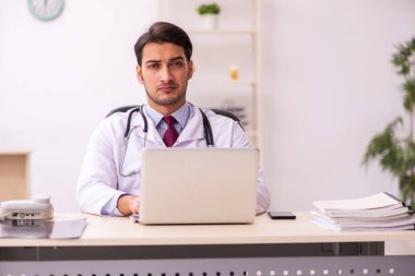 Klinikte çalışan genç erkek doktor.