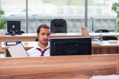 Genç bir erkek işçi ve ofiste çok fazla iş var.