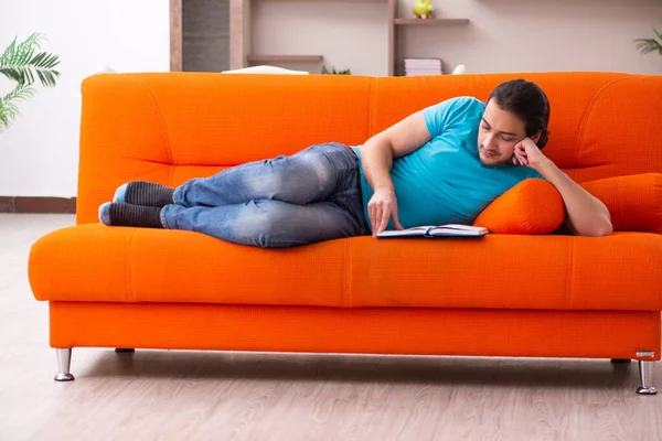 Jonge mannelijke student zittend op de oranje bank — Stockfoto