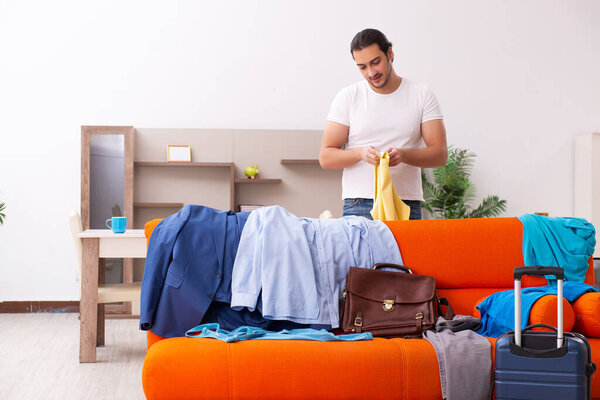 Young man student preparing for trip at home