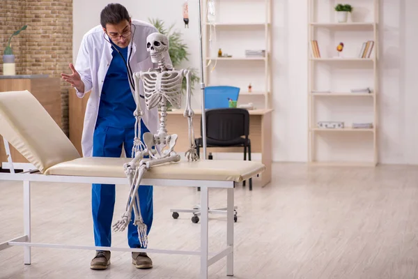 Jovem médico e paciente esqueleto na clínica — Fotografia de Stock