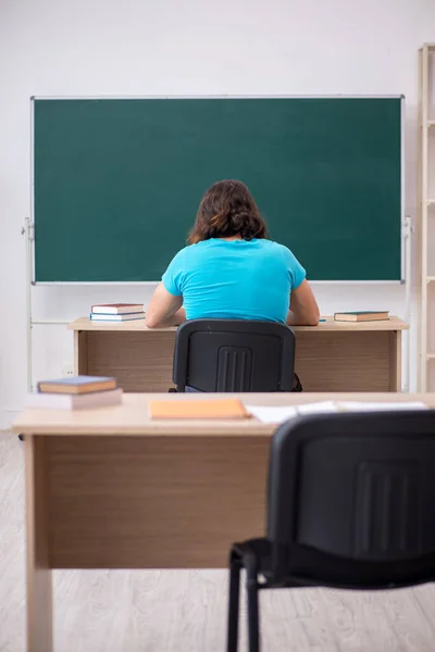 Joven estudiante masculino frente al tablero verde —  Fotos de Stock