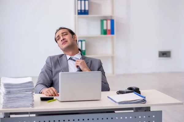 Jovem funcionário masculino infeliz com excesso de trabalho no escritório — Fotografia de Stock