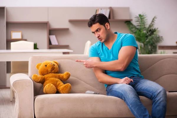 Young man sitting with bear toy at home — Stock Photo, Image