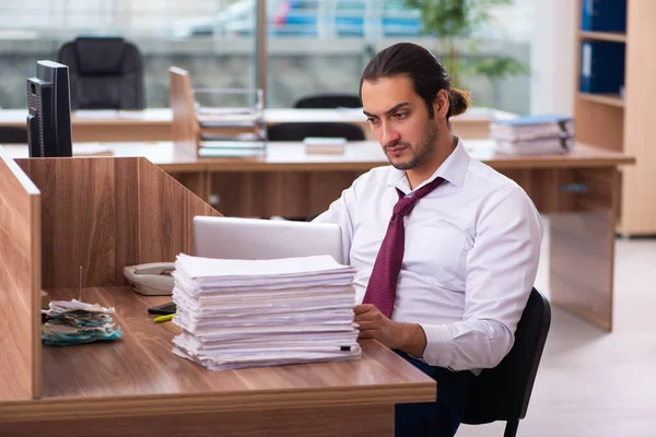 Jovem funcionário masculino e muitos trabalham no escritório — Fotografia de Stock