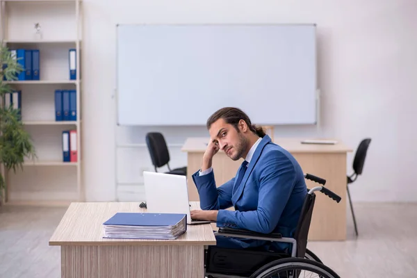 Młody pracownik na wózku inwalidzkim pracujący w biurze — Zdjęcie stockowe