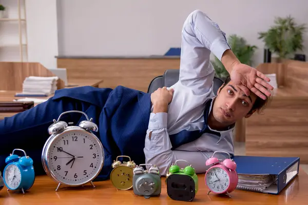 Joven empleado masculino durmiendo en la oficina en la gestión del tiempo co — Foto de Stock