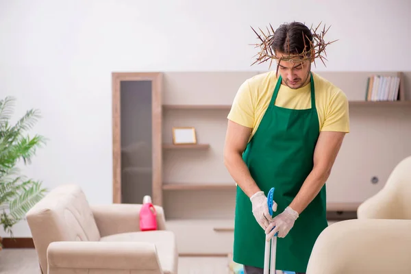 Young male contractor wearing prickly wreath on head cleaning th — Stock Photo, Image