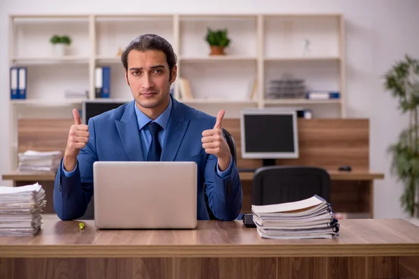 Joven empleado masculino y mucho trabajo en la oficina —  Fotos de Stock