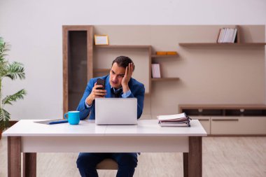 Genç erkek çalışan salgın sırasında evden çalışıyor.