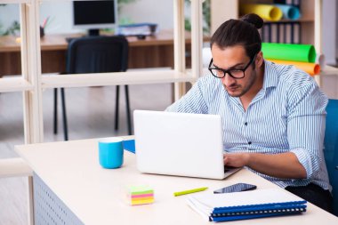 Ofiste çalışan genç bir erkek.