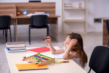 Evde sınava hazırlanan küçük kız.