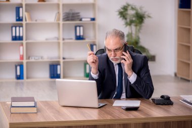 Ofiste çalışan yaşlı bir erkek.