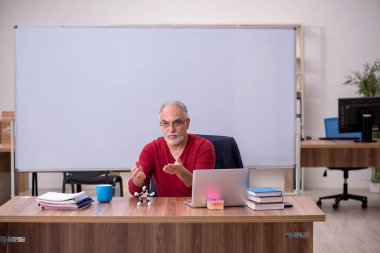 Sınıfta oturan eski bir fizikçi öğretmen.