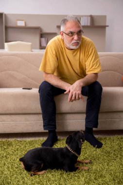 Evde köpeği olan yaşlı bir adam.