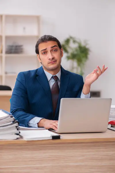 Giovane dipendente maschio infelice con il lavoro eccessivo — Foto Stock