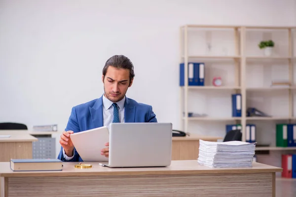 Jeune employé masculin et trop de travail au bureau — Photo