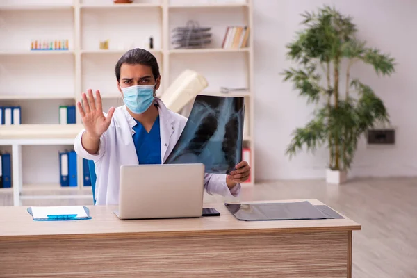 Młody lekarz radiolog noszący maskę twarzy podczas pandemii — Zdjęcie stockowe