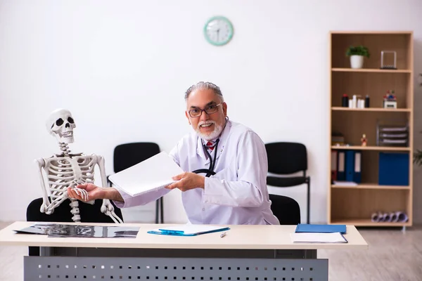 Gammal manlig läkare och skelettpatient på kliniken — Stockfoto