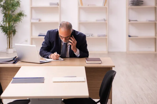 Velho empregador do sexo masculino sentado no escritório — Fotografia de Stock