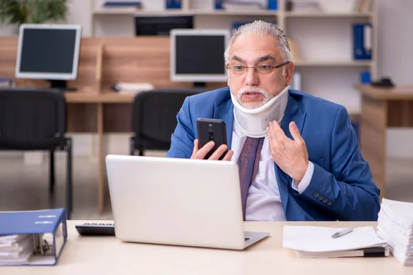 Velho empresário empregado após acidente de trabalho no escritório — Fotografia de Stock