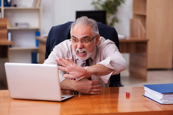 Old male employee in gambling concept at workplace — Stock Photo, Image