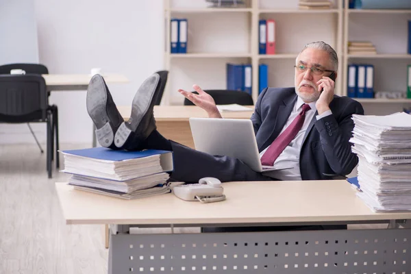 Überalterte männliche Mitarbeiter und zu viel Arbeit am Arbeitsplatz — Stockfoto