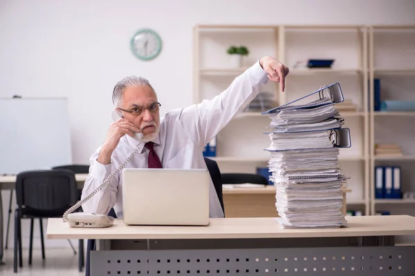 Empleado de edad avanzada y demasiado trabajo en el lugar de trabajo —  Fotos de Stock