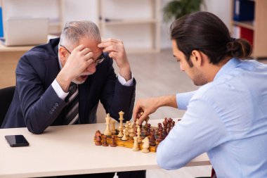 Ofiste satranç oynayan iki işadamı.