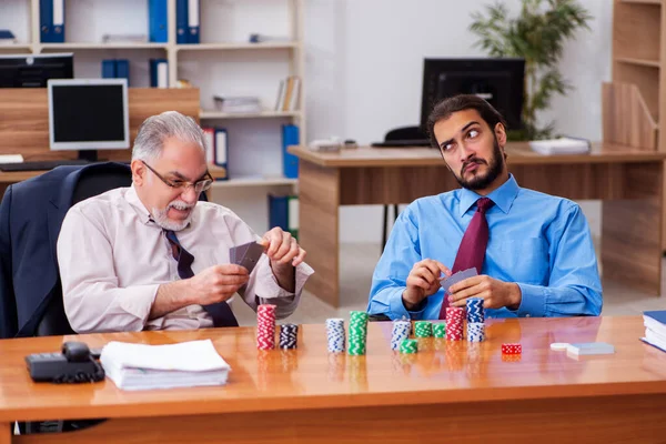 Twee mannelijke werknemers die kaarten op de werkplek — Stockfoto