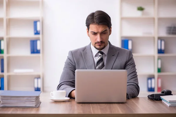 Ung attraktiv manlig anställd sitter på arbetsplatsen — Stockfoto