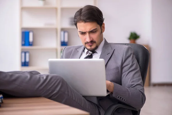 Jeune homme attrayant assis sur le lieu de travail — Photo