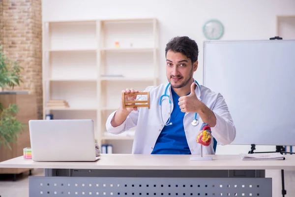 Jovem médico cardiologista no conceito de gerenciamento de tempo — Fotografia de Stock