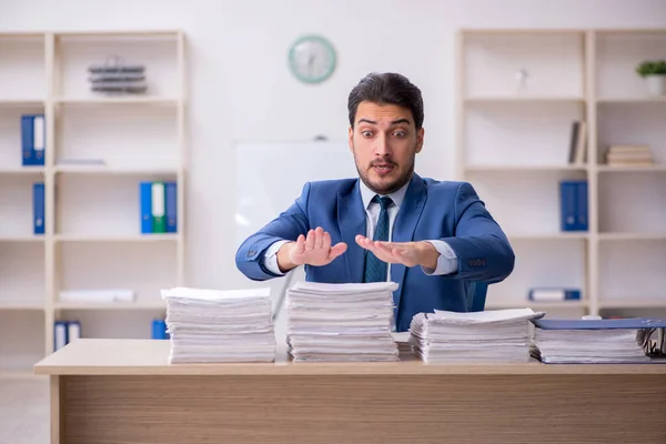 Jovem funcionário masculino infeliz com excesso de trabalho no escritório — Fotografia de Stock