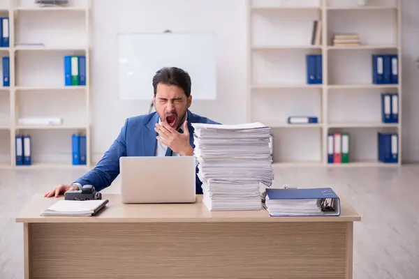 Giovane dipendente maschio infelice con un lavoro eccessivo in ufficio — Foto Stock