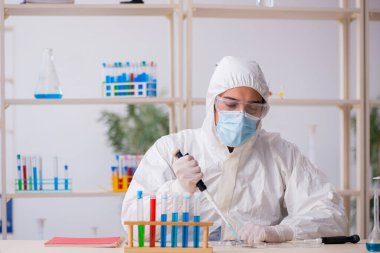 Salgın sırasında laboratuvarda çalışan genç bir kimyager.