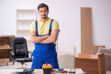 Genç erkek marangoz ofiste çalışıyor.