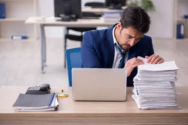 Ung manlig anställd missnöjd med överdrivet arbete på kontoret — Stockfoto