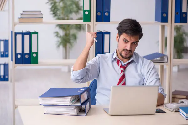 Jonge mannelijke werknemer werkzaam in het kantoor — Stockfoto