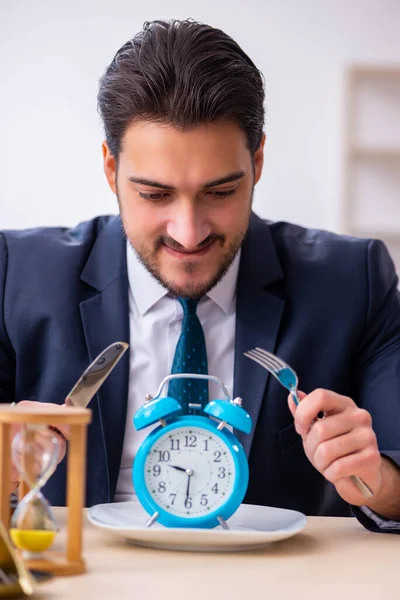Fiatal üzletember alkalmazott eszik ébresztőórát — Stock Fotó