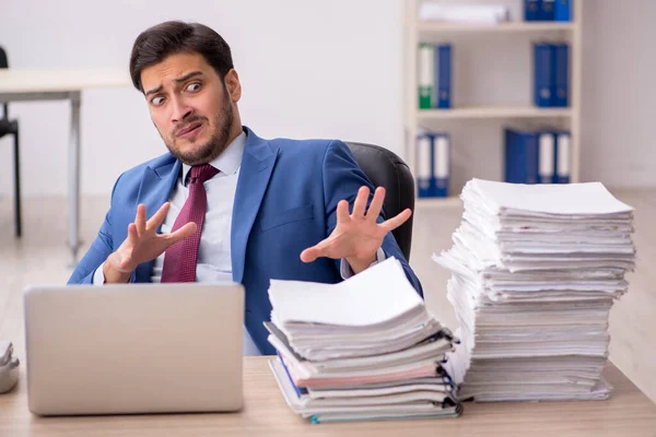 Junge männliche Mitarbeiter und zu viel Arbeit im Büro — Stockfoto