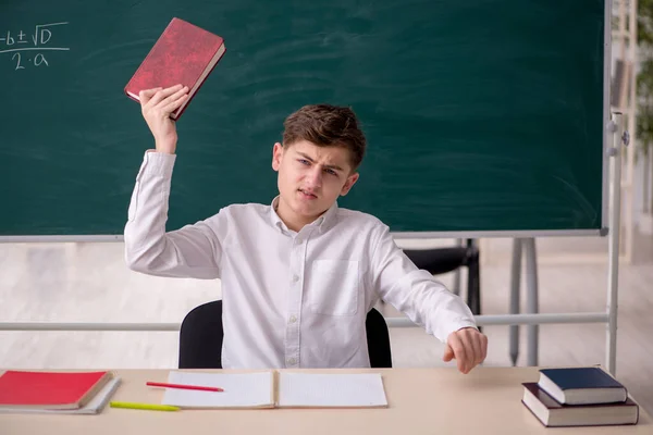 Menino sentado na sala de aula — Fotografia de Stock