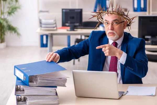 Alter männlicher Angestellter trägt stacheligen Kranz auf dem Kopf — Stockfoto