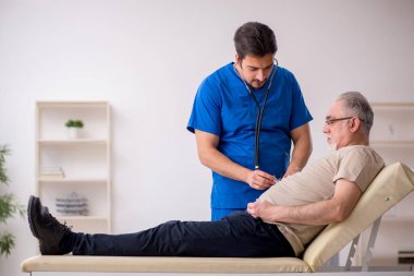 Yaşlı erkek hasta, genç doktor.